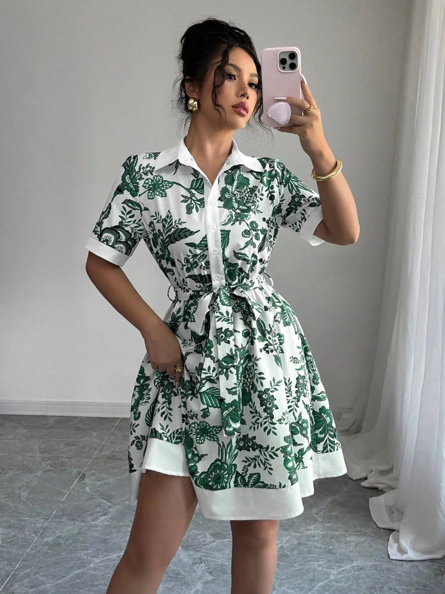 Woman taking a mirror selfie wearing a green and white floral dress.