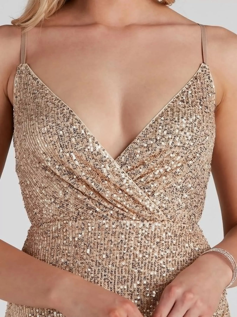 Close-up of a woman wearing a champagne gold sequined dress with thin straps and a deep V-neckline.