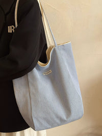 Person holding a light blue striped tote bag against a beige background