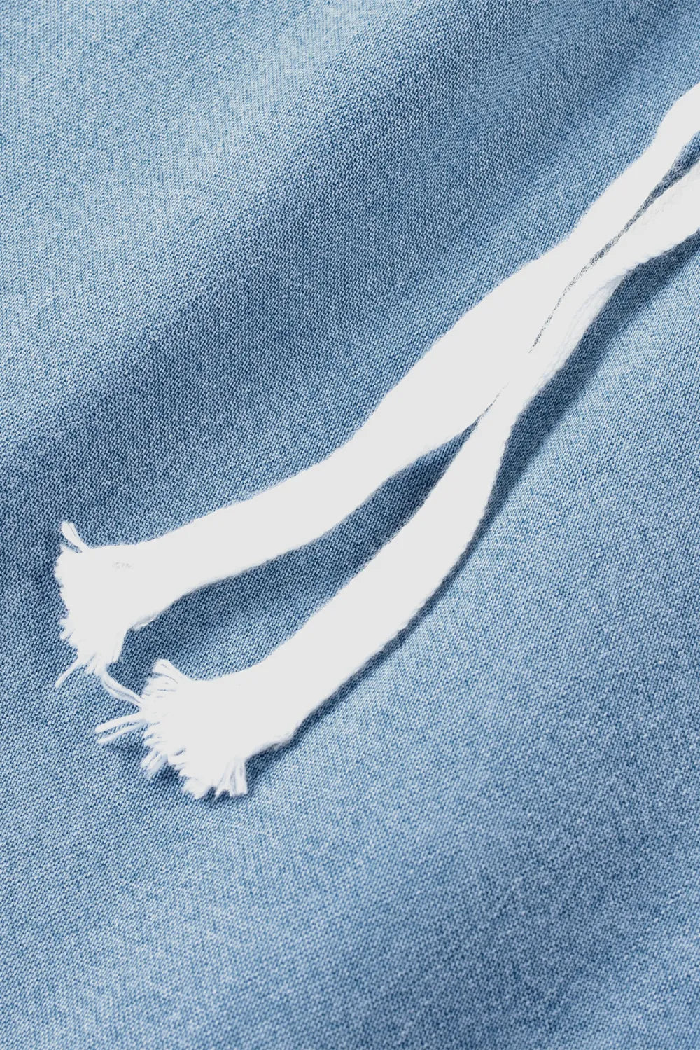 White frayed cord on a blue denim background