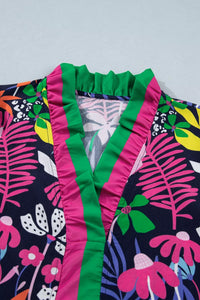Close-up of a colorful floral dress with green trim on a light gray background