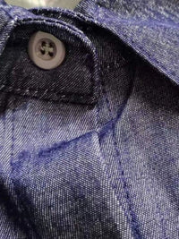 Close-up of a button on blue denim fabric