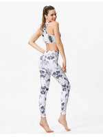Woman wearing a floral sports bra and leggings set on a white background