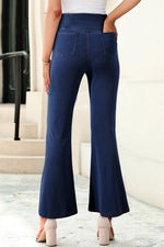 Navy blue flared pants worn by a person on a light background