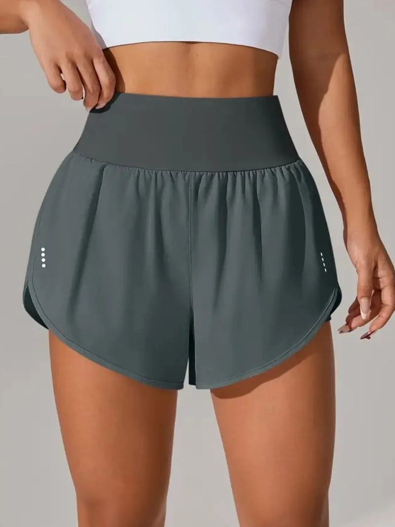 Person wearing dark green athletic shorts on a plain background