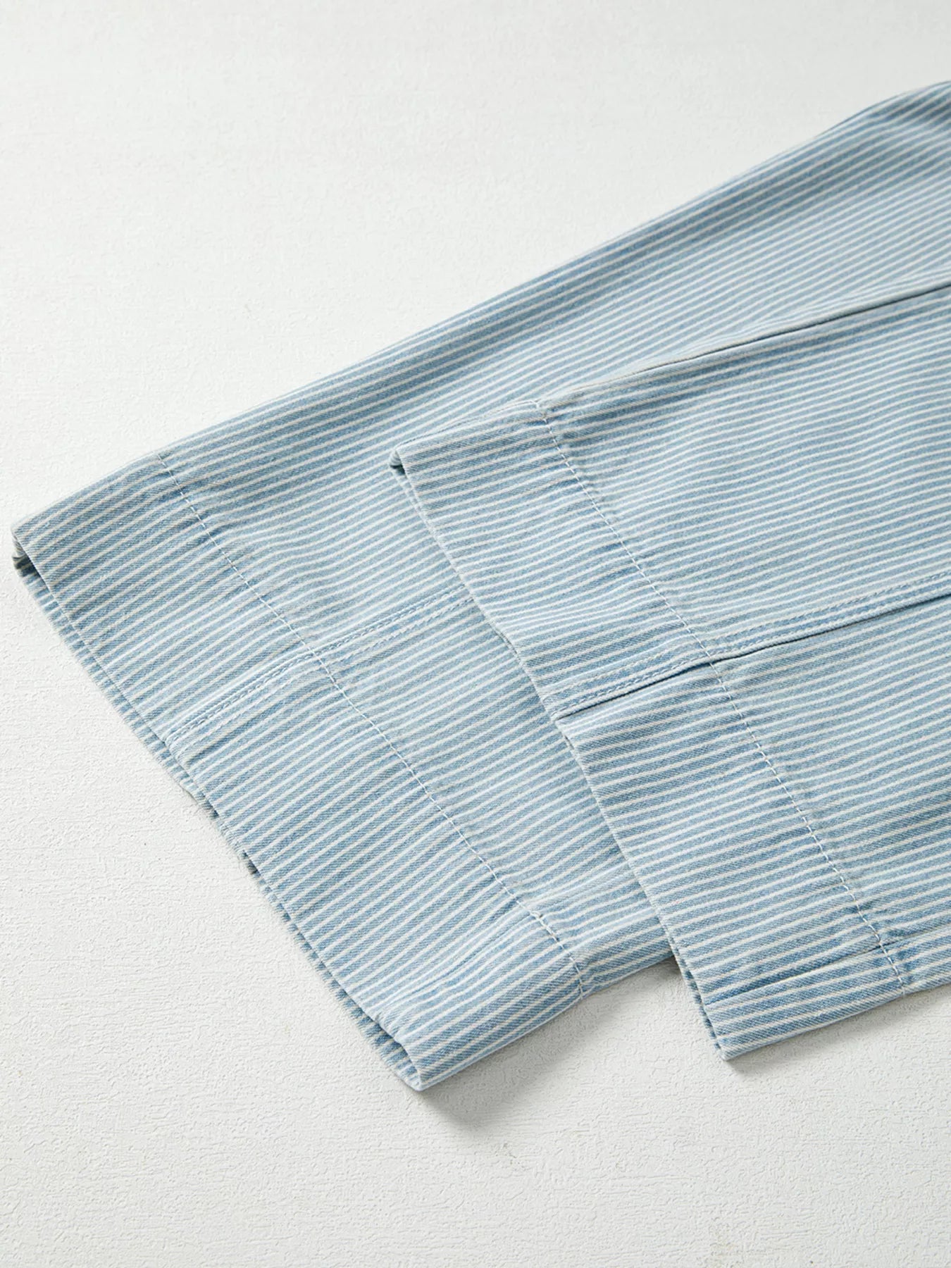 Folded light blue towel on a white background