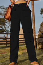 Person wearing black cargo pants with a blurred outdoor background