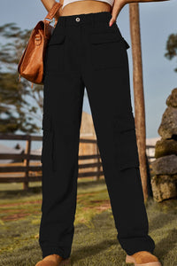 Person wearing black cargo pants with a blurred outdoor background