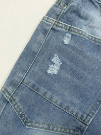 Close-up of a blue denim jacket with distressed details on a light background