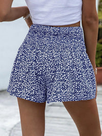 Person wearing a blue floral skirt with a blurred background