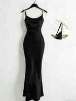 Black slip dress on a hanger against a white background