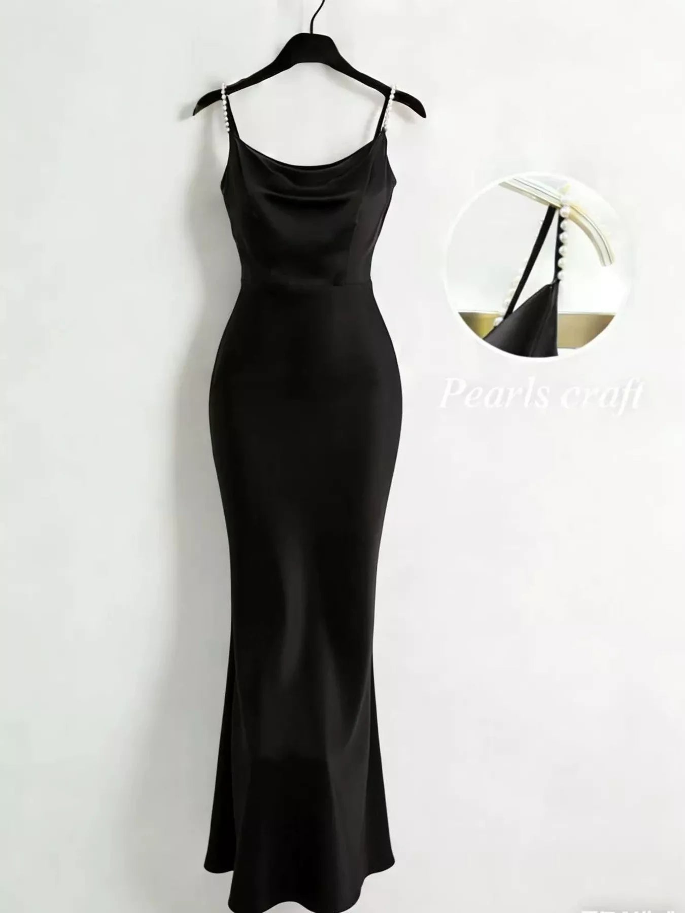 Black slip dress on a hanger against a white background