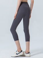 Person wearing dark gray leggings on a light gray background