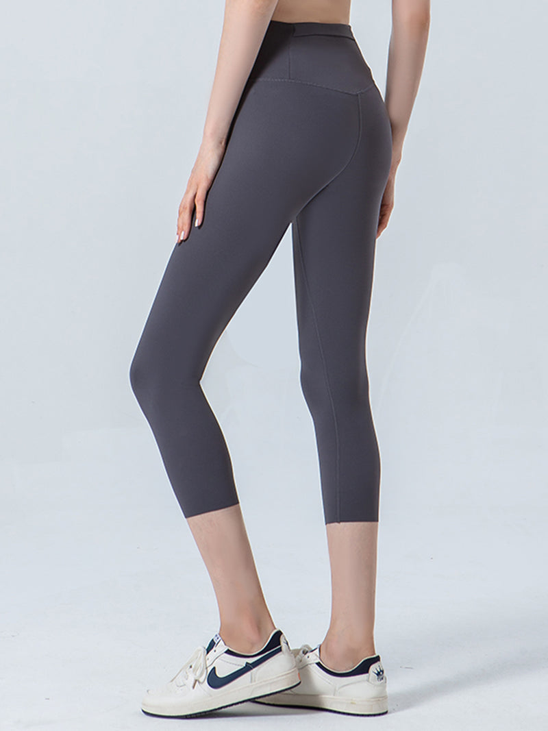 Person wearing dark gray leggings on a light gray background