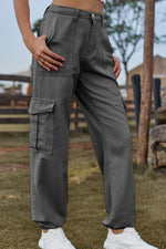 Person wearing gray cargo pants with a blurred outdoor background