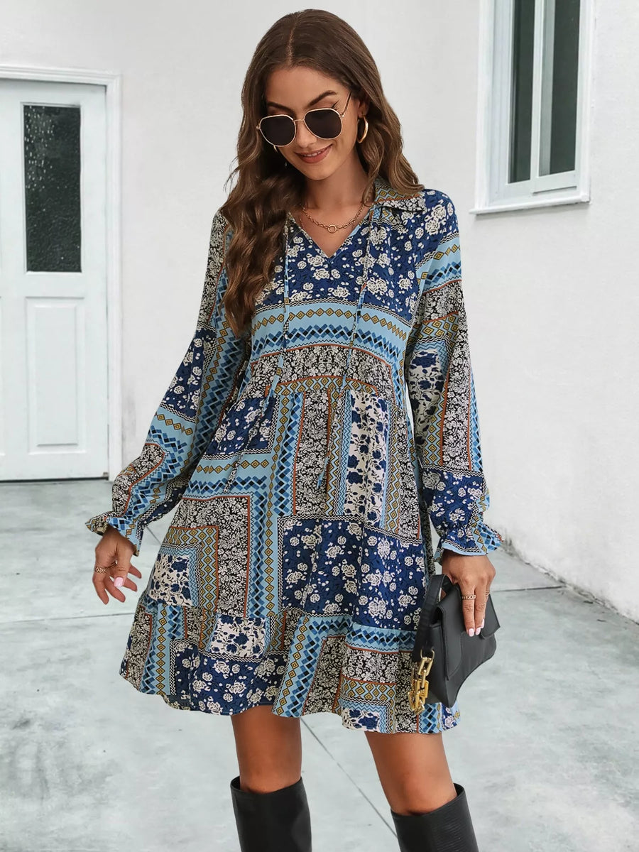 Woman wearing a patterned dress with long sleeves in an outdoor setting.