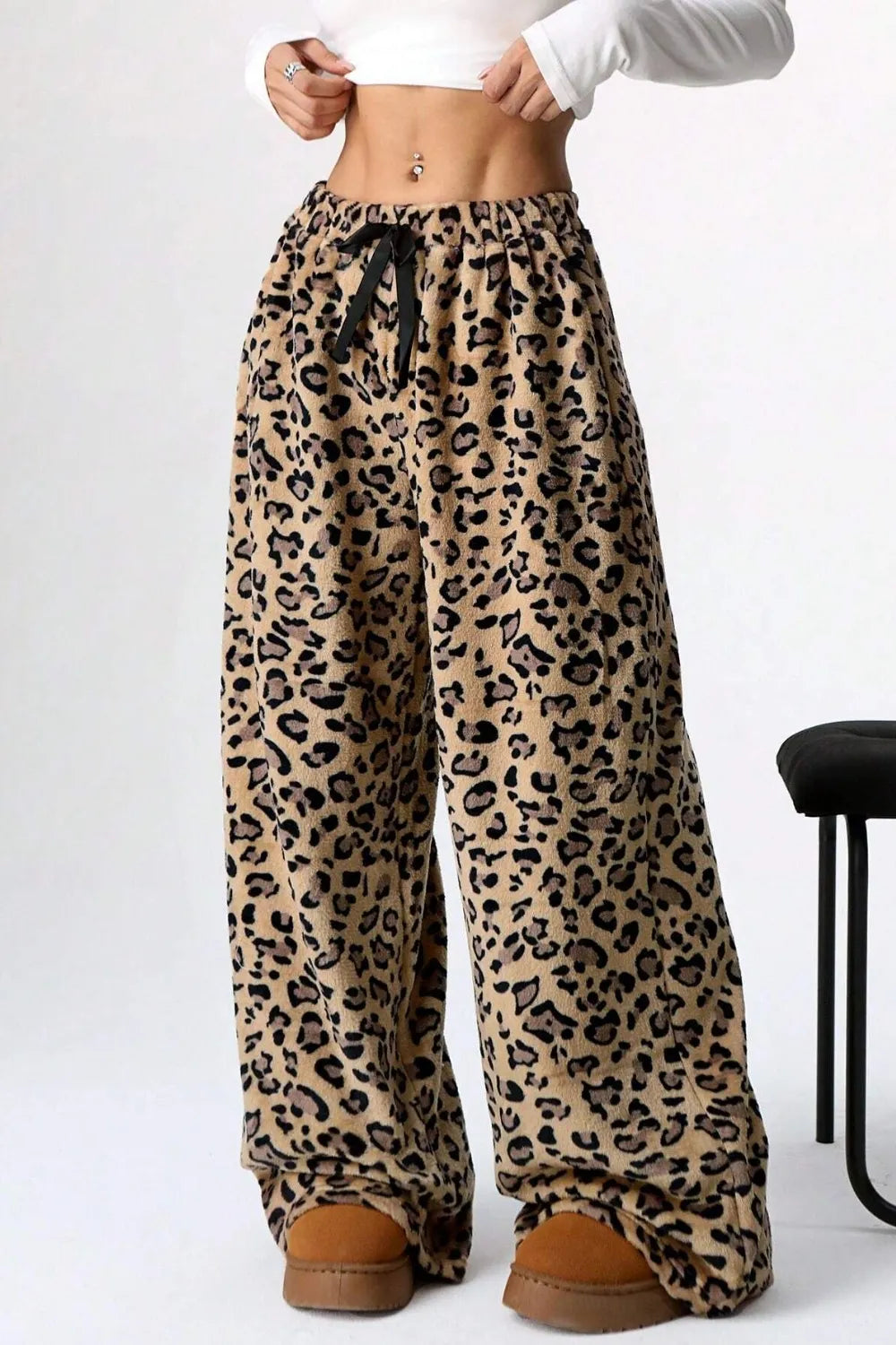 Leopard print pants worn by a person on a white background