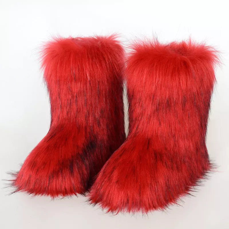 Pair of red furry boots on a white background