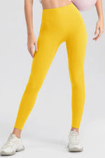 Yellow leggings worn by a person on a white background