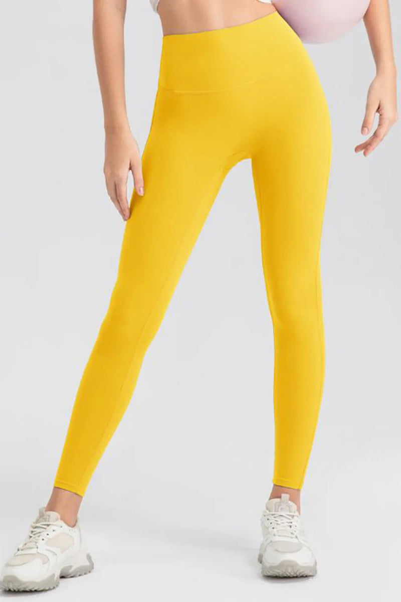 Yellow leggings worn by a person on a white background