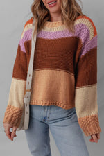 Person wearing a colorful striped sweater with a plain background