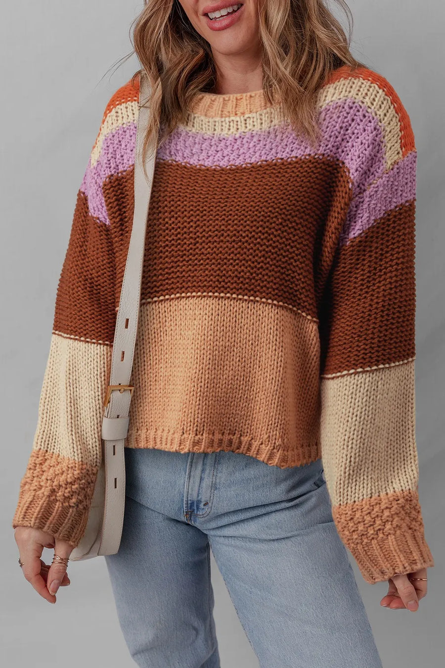 Person wearing a colorful striped sweater with a plain background