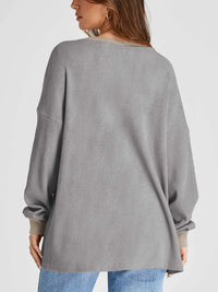 Gray ribbed sweater worn by a person on a light gray background