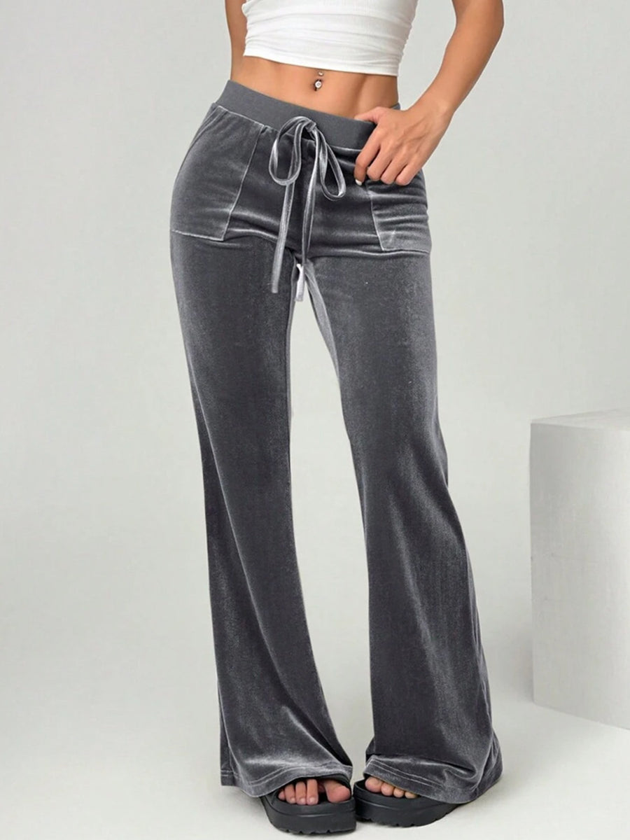 Gray wide-leg pants with a tie waist worn by a person on a light gray background