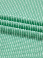 Close-up of green fabric with a subtle pattern