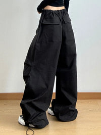 Person wearing black wide-leg pants on a plain background