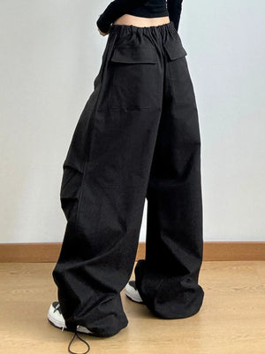 Person wearing black wide-leg pants on a plain background