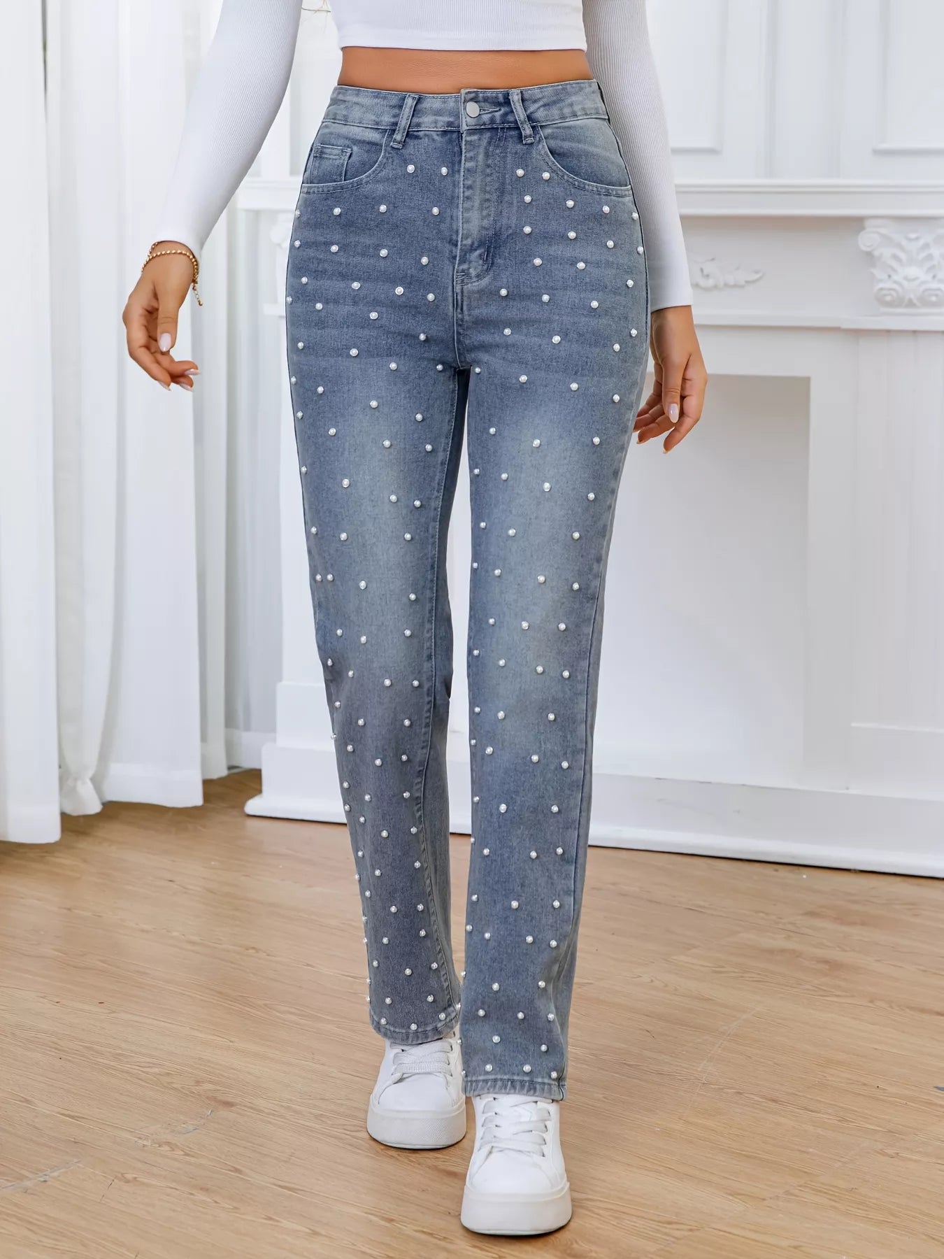 Person wearing light blue jeans with white polka dots indoors.