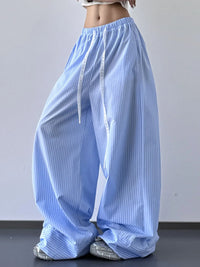 Light blue striped pants worn by a person on a plain background