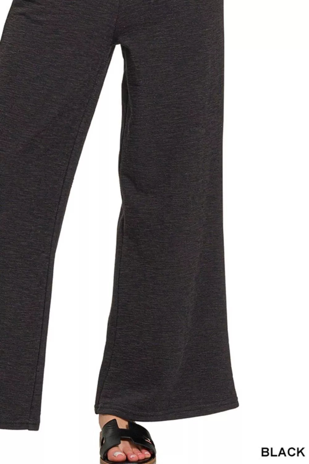 Black pants on a white background with 'BLACK' text at the bottom right corner.