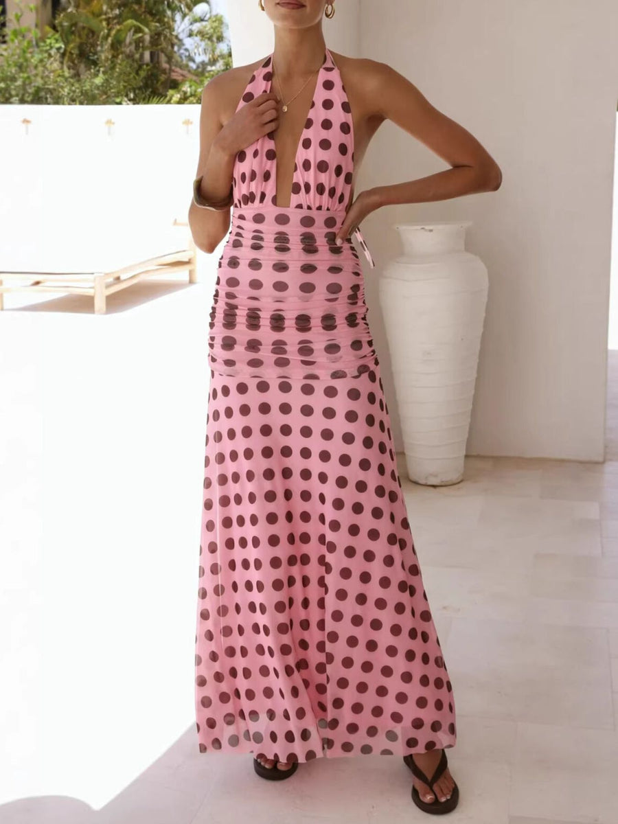 Woman wearing a pink polka dot dress in an outdoor setting