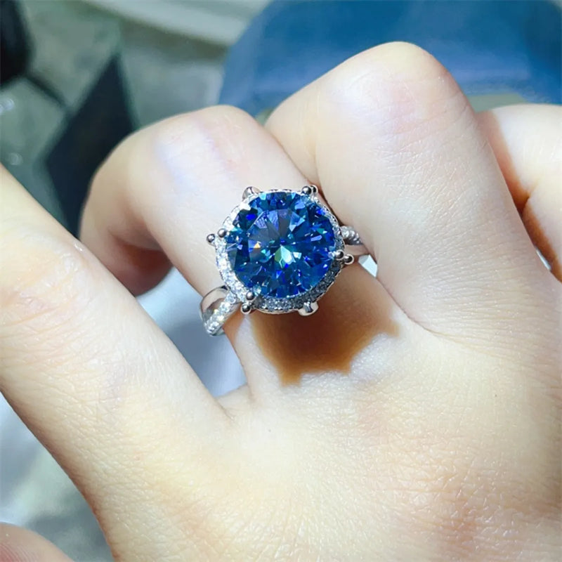 Close-up of a hand wearing a ring with a blue gemstone.
