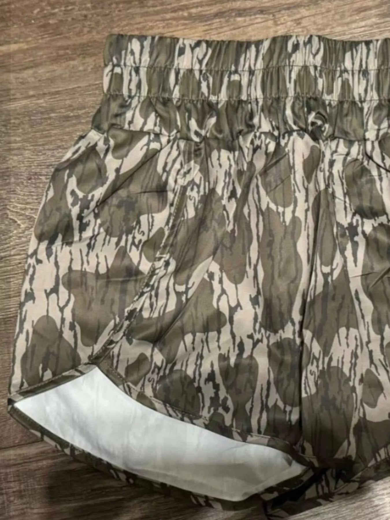 Camouflage-patterned shorts on a wooden surface