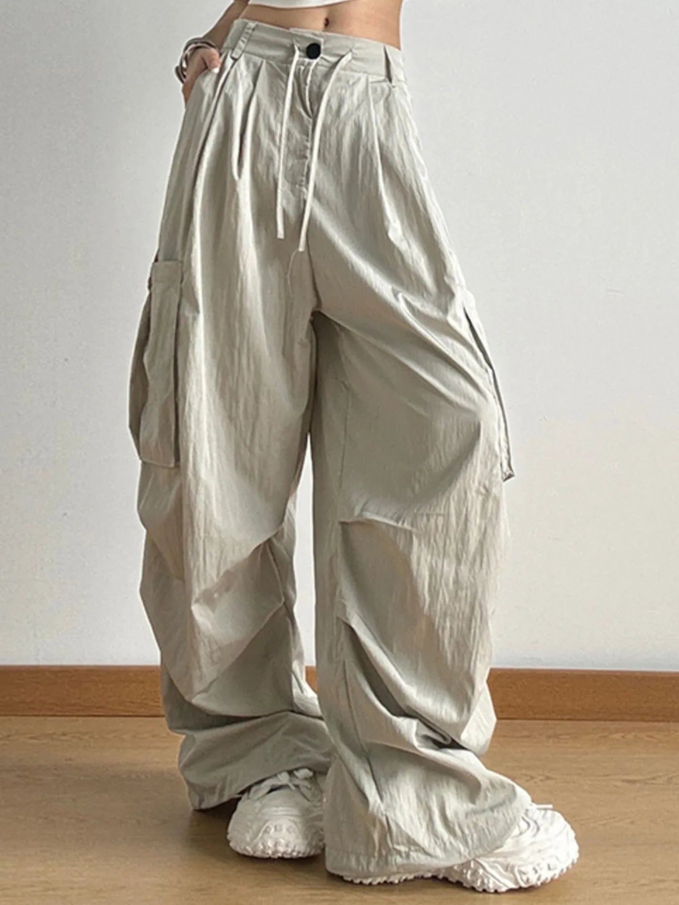 Beige wide-leg pants worn by a person on a plain background