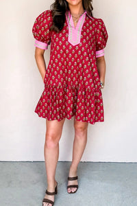 Woman wearing a red floral dress against a white background