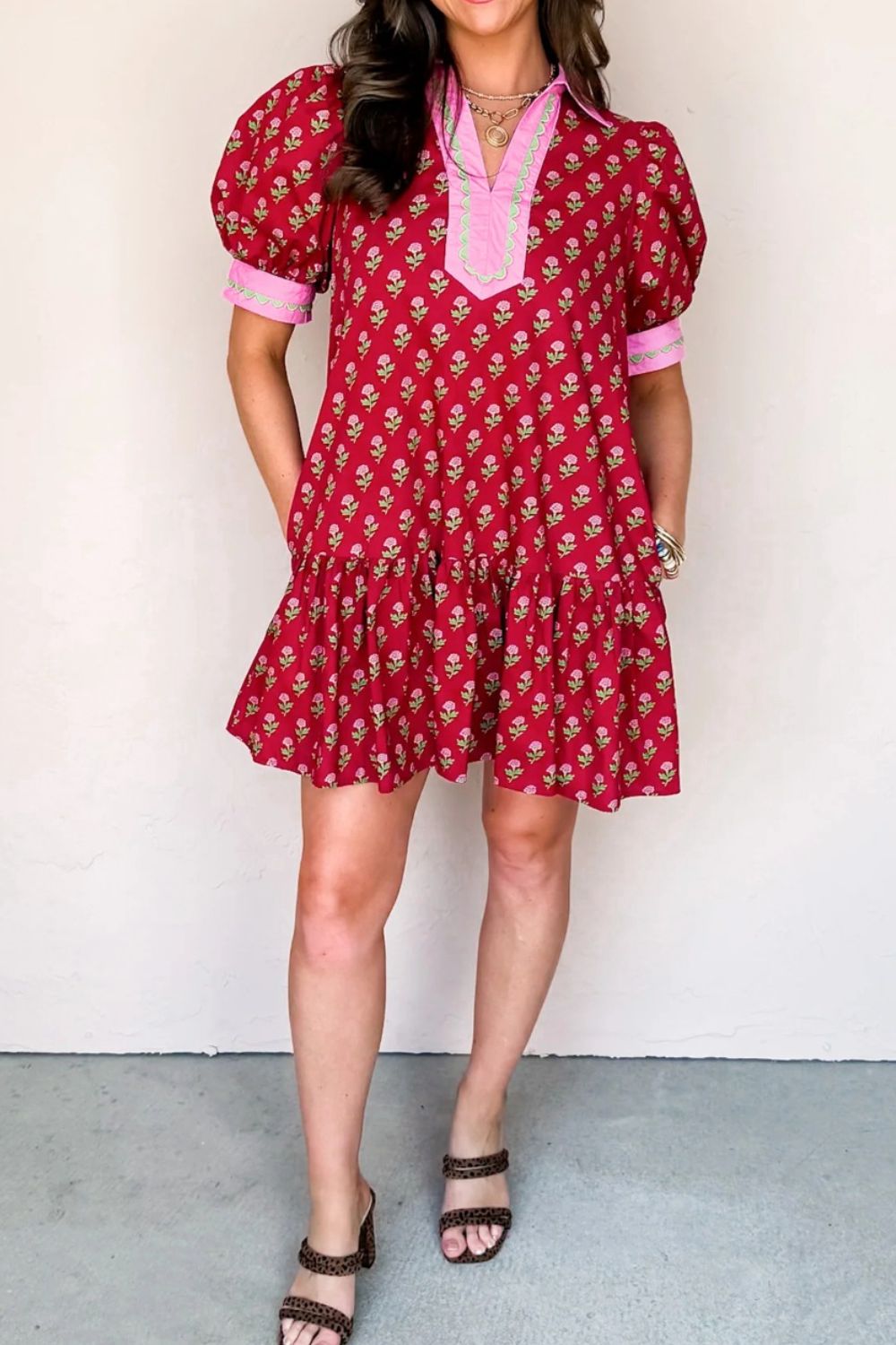 Woman wearing a red floral dress against a white background