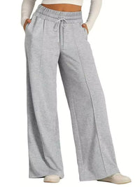 Gray sweatpants worn by a person on a white background