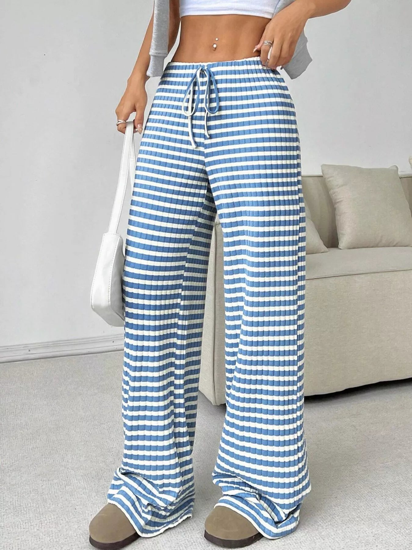 Person wearing blue and white striped pants in a living room setting
