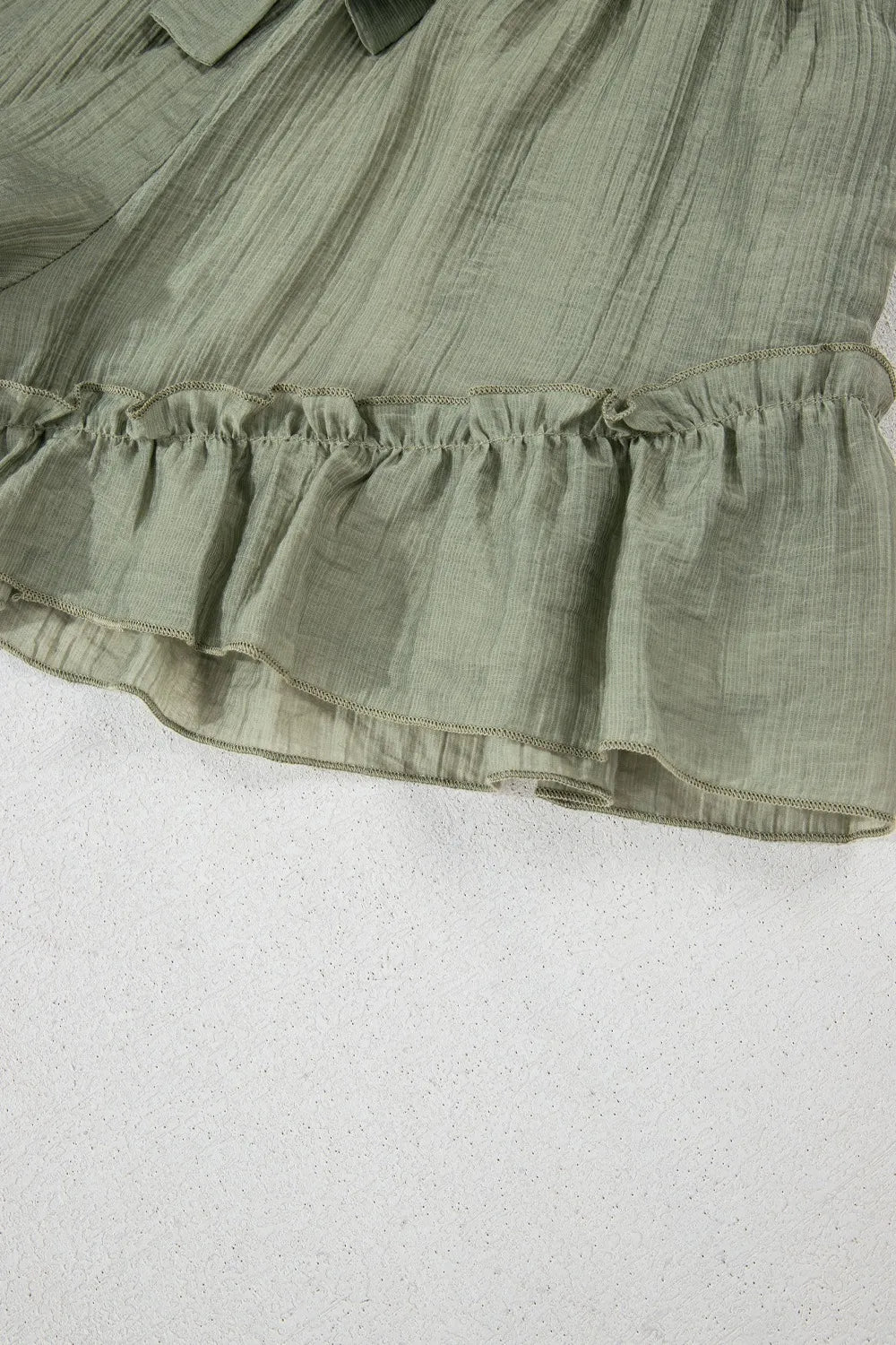 Green ruffled fabric on a white background