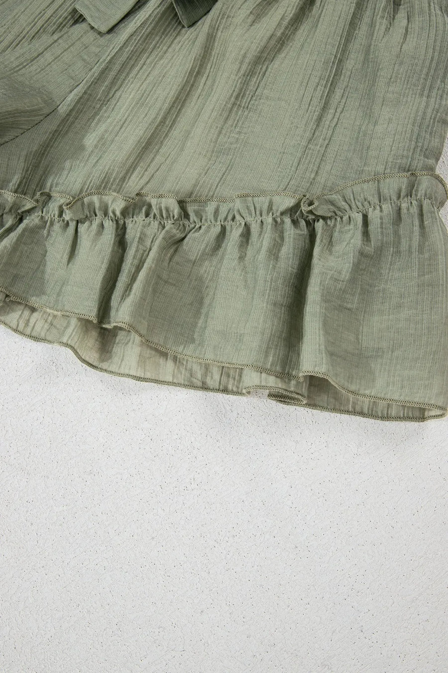 Green ruffled fabric on a white background