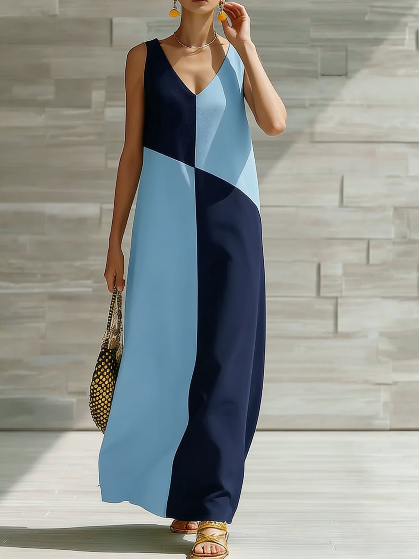 Woman wearing a blue and navy color-blocked dress against a stone wall.