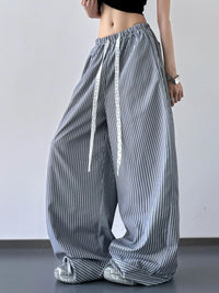 Person wearing wide-leg striped pants on a plain background