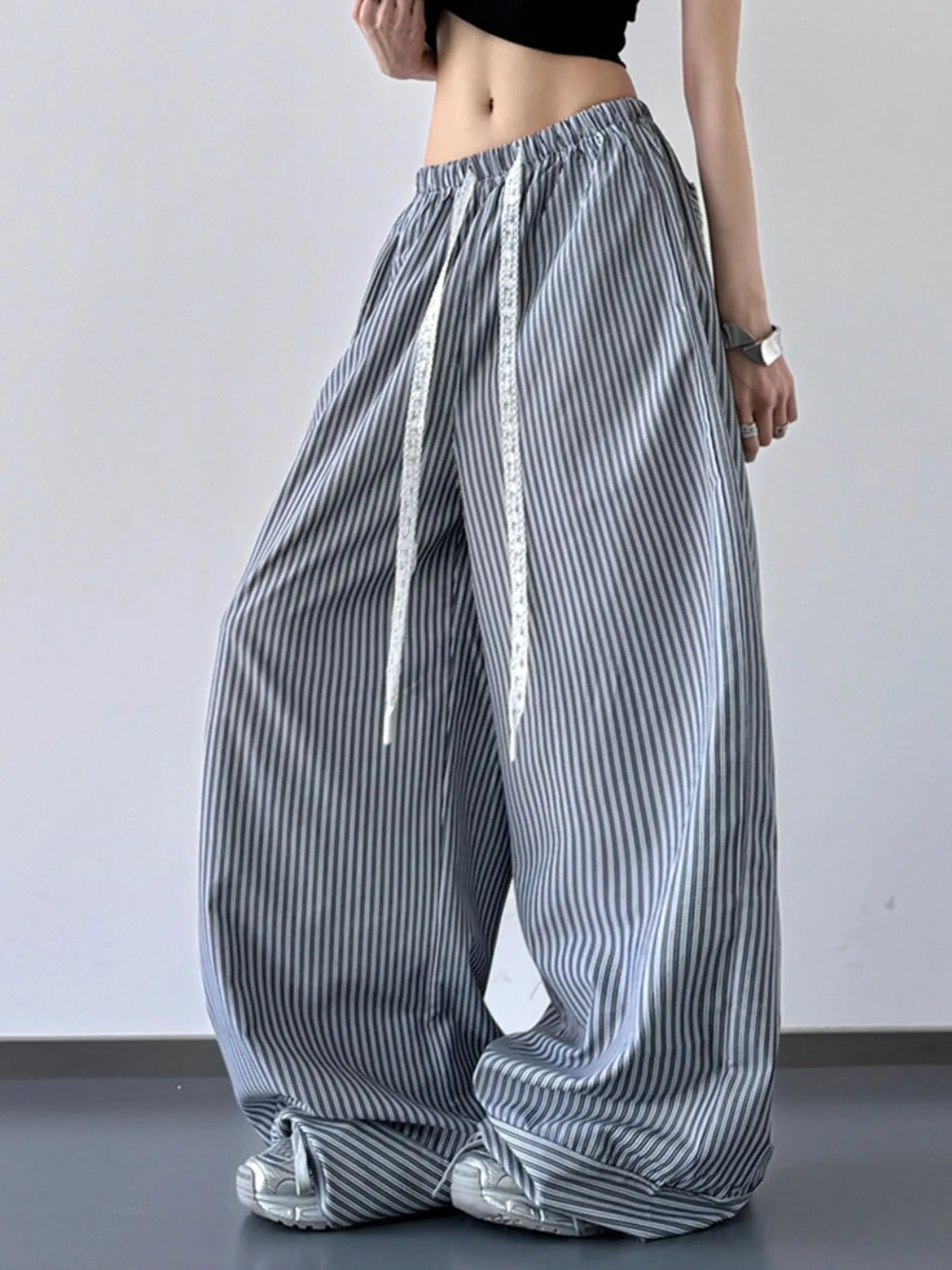 Person wearing wide-leg striped pants on a plain background