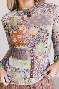 Person wearing a colorful floral-patterned shirt with a plain background