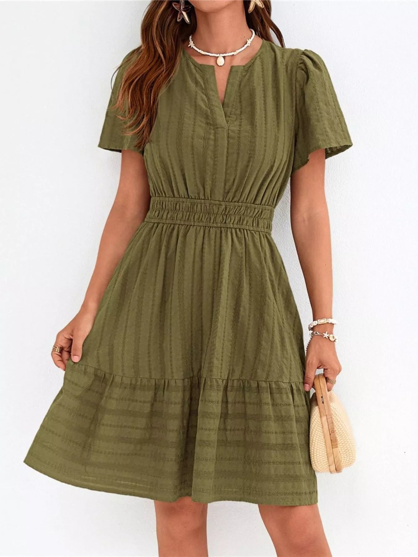 Woman wearing a green dress against a white background