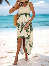 Woman in a green and white patterned dress on a beach